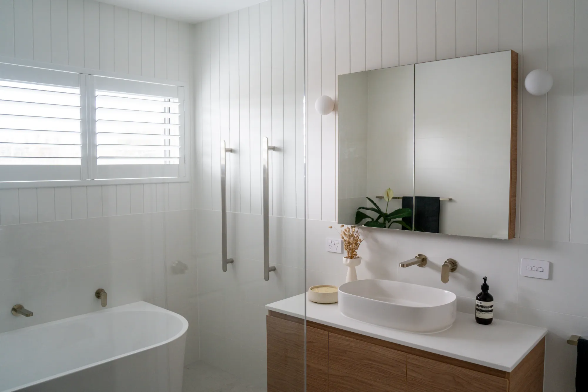 White bathroom with timber vanity and freestanding bath
