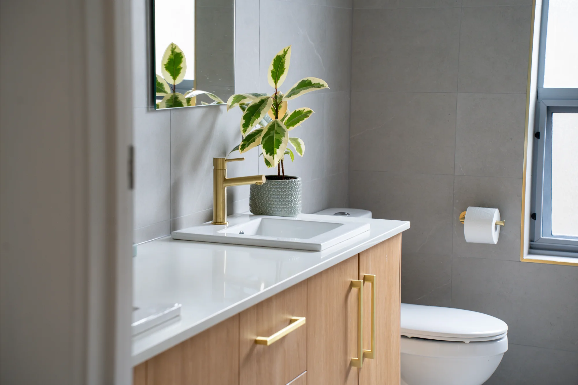 Compact bathroom with timber vanity and grey tiles